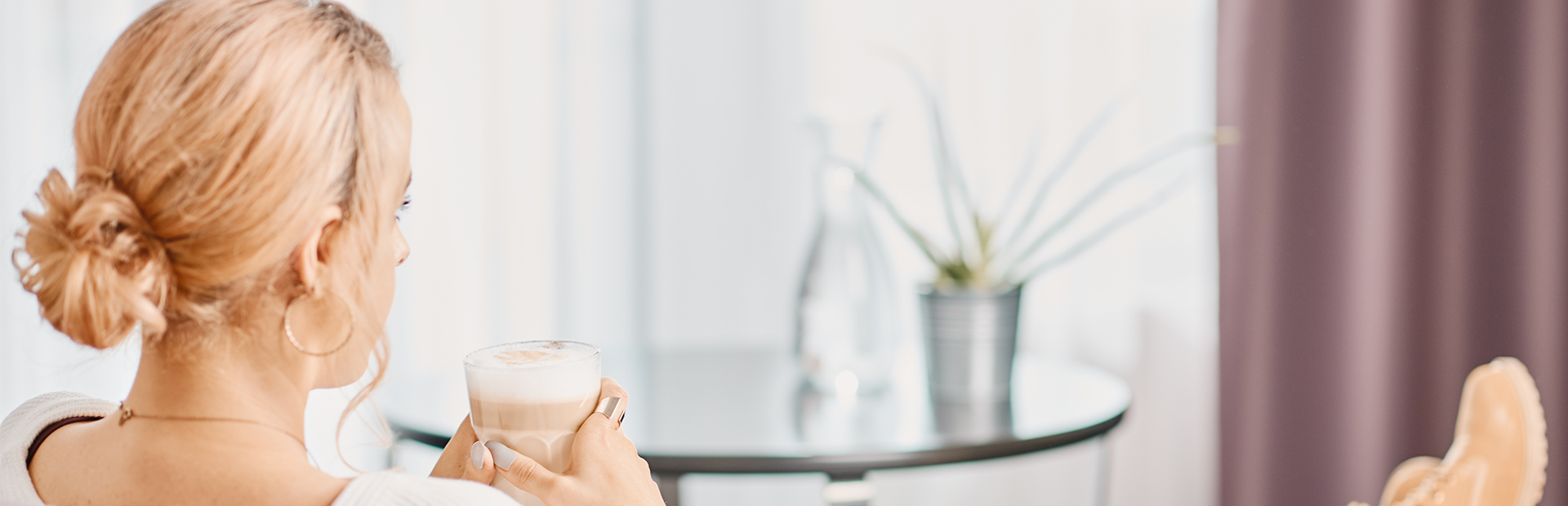 Woman enjoying a latte machattio in a junior suite