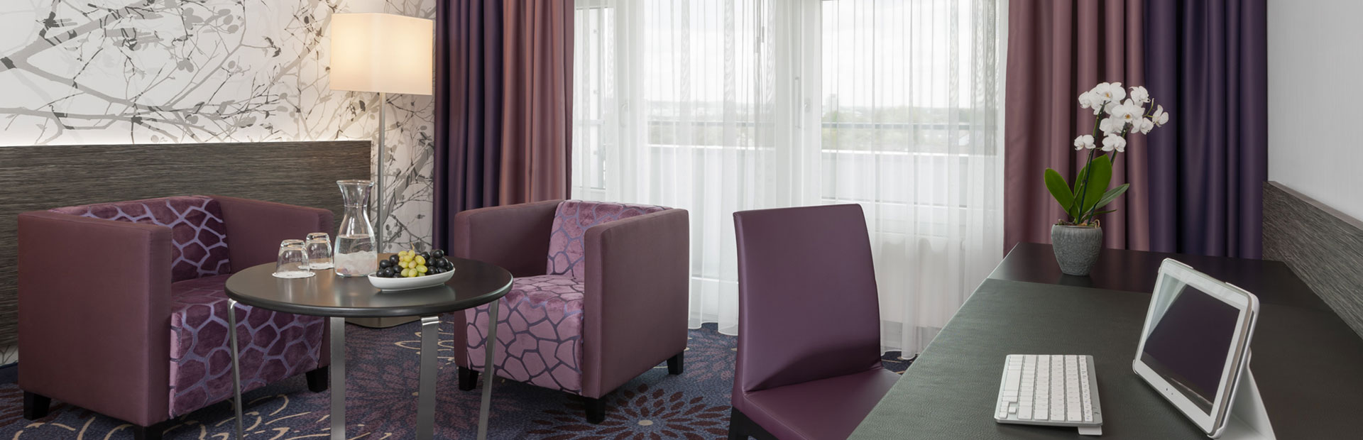 Comfortable standard room with stylish purple seating are